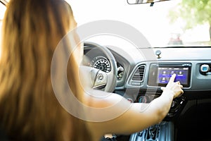 Woman driving car and using infotainment