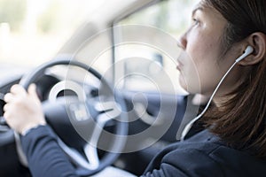 Woman driving a car and using mobile phone for calling