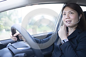 Woman driving a car and using mobile phone for calling