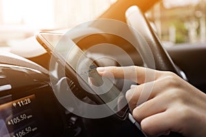 Woman driving a car with using navigation on smartphone.technology