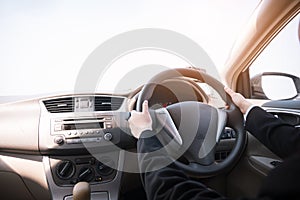 Woman driving her car, hands holding steering wheel