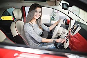 Woman driving new and modern car and turn button on dashboard panel in car