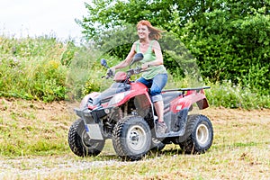 Woman driving off-road with quad bike