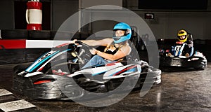 Woman driving racing car at kart circuit