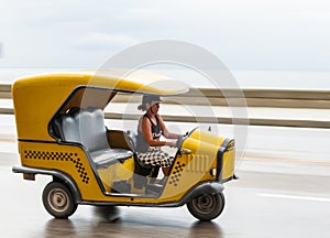 HAVANA, CUBA - OCTOBER 21, 2017: Woman Driving Tuk Tuk Taxi in Havana, Cuba