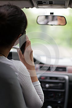 Woman driving and using cell phone