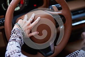 Woman driving yellow sports car with hand hold steering wheel