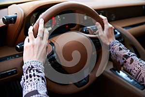 Woman driving yellow sports car with hand hold steering wheel