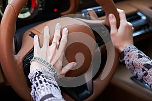 Woman driving yellow sports car with hand hold steering wheel