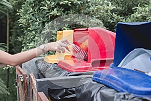 Woman drop plastic bottle into recycle bin.