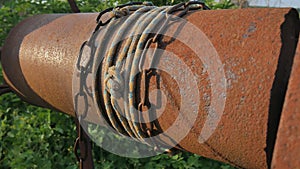Woman drops chain with bucket into rustic well to draw water. Vintage water well chain close up. Old rusty chain of the