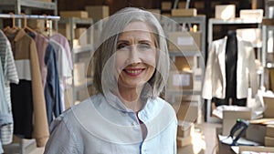 Woman dropshipping clothing business owner in warehouse, headshot portrait.