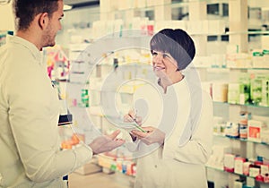 Woman druggist wearing white coat