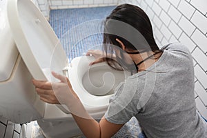 Woman drunk hangover puke in toilet bowl. Female have abdominal pain, nausea, dizziness, nausea, vomit due to food poisoning