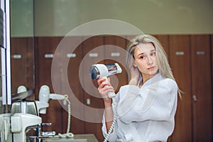 Woman dry hair hairdryer at bathroom. Female with dryer home