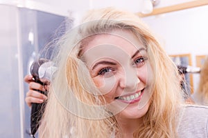 Woman drying hair in bathroom