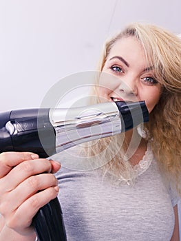 Woman drying hair in bathroom