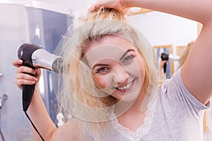 Woman drying hair in bathroom