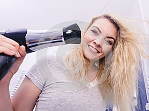 Woman drying hair in bathroom