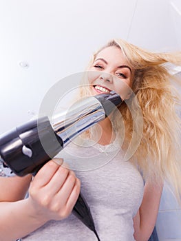 Woman drying hair in bathroom