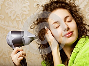 Woman drying her hair with hairdryer