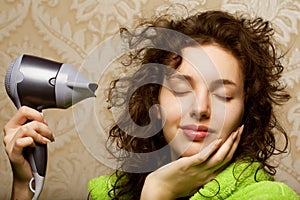 Woman drying her hair with hairdryer