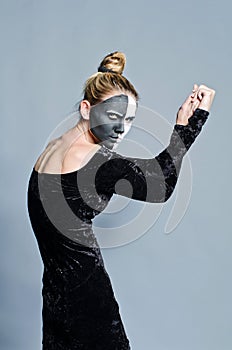 Woman with dual greasepaint and clasped hands