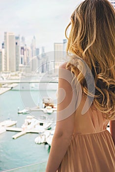 Woman in Dubai Marina, United Arab Emirates. Attractive lady wearing a long dress admiring Marina daylight views