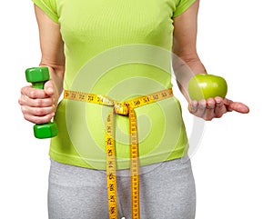 Woman with dumbbells and apple