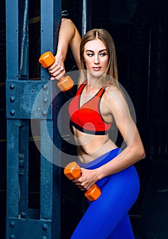 Woman with dumbbells in the gym
