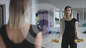 Woman with dumbbells in sport centre