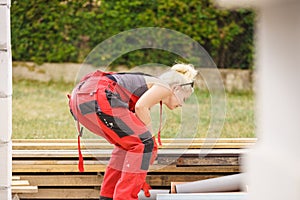 Woman in dungarees working on construction site