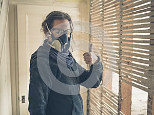 Woman with dust mask and goggles giving thumbs up