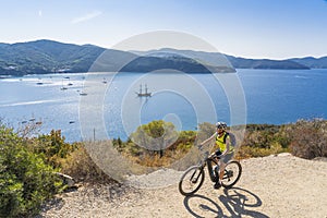 Woman with e bike on Elba Island, Italy