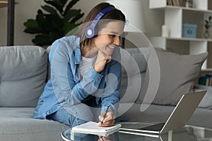 Woman e-learn use laptop listen audio course through wireless headphones