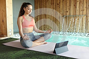 Woman e-learning yoga in spa