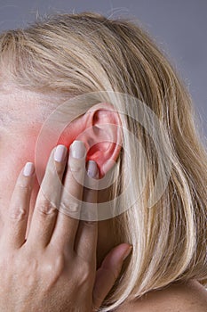 Woman with earache, ear pain closeup photo