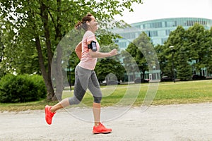 Woman with earphones add armband jogging at park