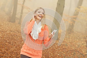 Woman with earphones listening to music in park.