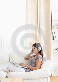 Woman with earphones sitting on sofa