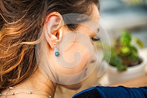 Woman and earrings made of natural stones. The mysticism of amulets. Esoterics in handmade jewelry close-up and copy space. Jewelr