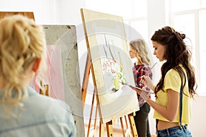 Woman with easel painting at art school studio