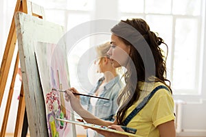 Woman with easel painting at art school studio