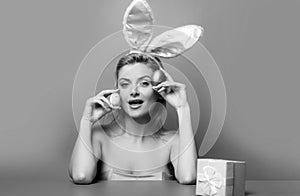 Woman with Easter eggs. Cute girl wearing bunny ears on Easter day.