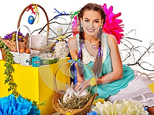 Woman in easter style holding eggs and flowers.