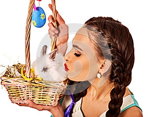 Woman in easter style holding eggs and flowers.