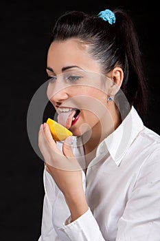 Woman eat yellow lemon