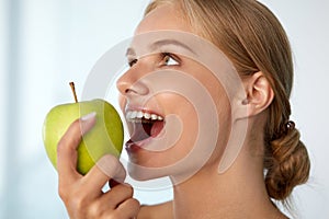 Woman Eating Apple. Beautiful Girl With White Teeth Biting Apple