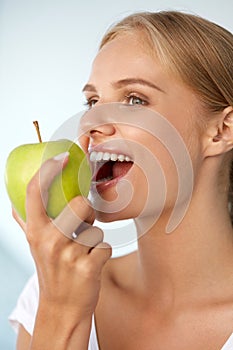 Woman Eating Apple. Beautiful Girl With White Teeth Biting Apple