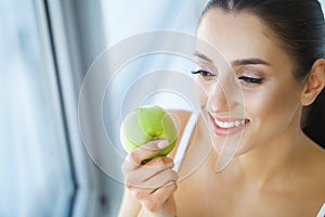 Woman Eating Apple. Beautiful Girl With White Teeth Biting Apple